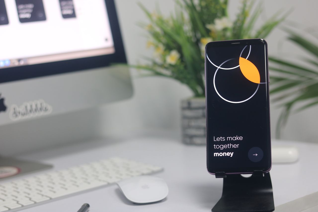 Un espace de travail contemporain avec un smartphone affichant un écran et un ordinateur, parfait pour des thèmes liés à l’entreprise et à la technologie.